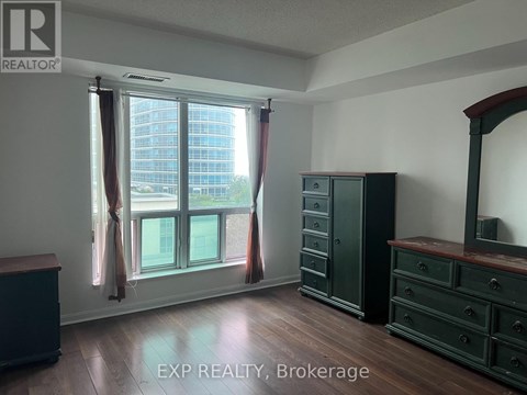 A room with a large window and wooden floors.