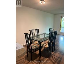 A glass dining table with four chairs in a room.