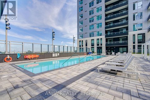 A swimming pool on a rooftop with a building in the background.