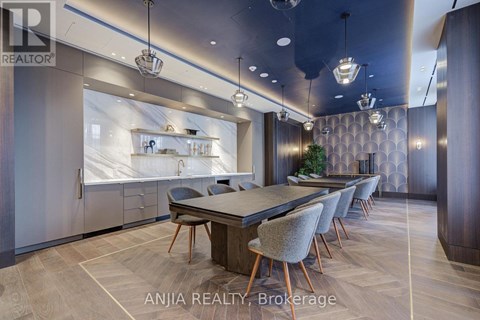 A modern dining room with a large table and chairs.