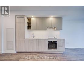 A modern kitchen with wooden cabinets and a stainless steel oven.