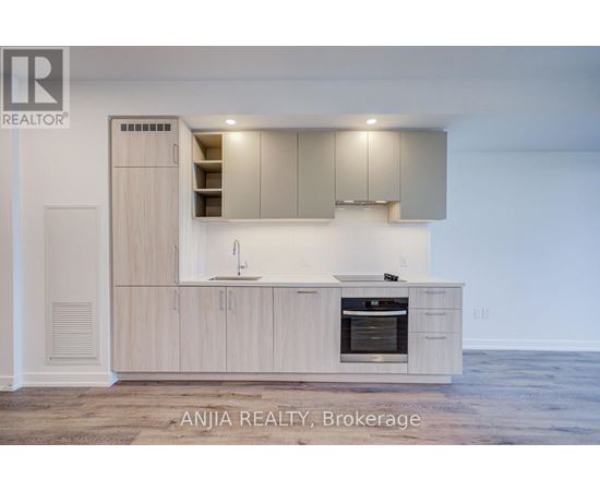 A modern kitchen with wooden cabinets and a stainless steel oven.