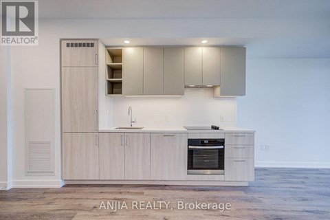 A modern kitchen with wooden cabinets and a stainless steel oven.