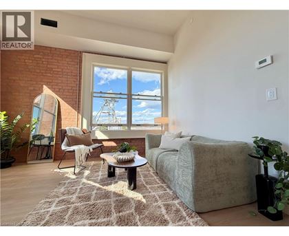 A living room with a couch, chair, and a table with a plant on it.