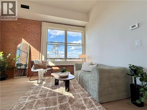 A living room with a couch, chair, and a table with a plant on it.