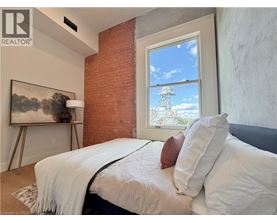 A bedroom with a large bed and a painting on the wall.
