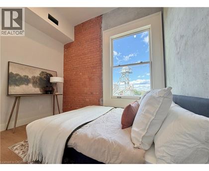 A bedroom with a large bed and a painting on the wall.