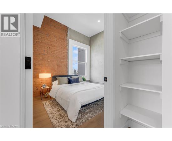 A bedroom with a large bed and a painting on the wall.
