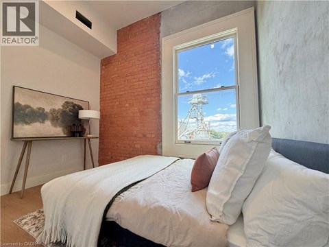 A bedroom with a large bed and a painting on the wall.
