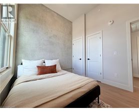 A bedroom with a large bed and a concrete wall.