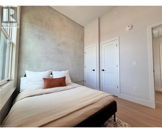 A bedroom with a large bed and a concrete wall.