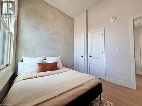 A bedroom with a large bed and a concrete wall.