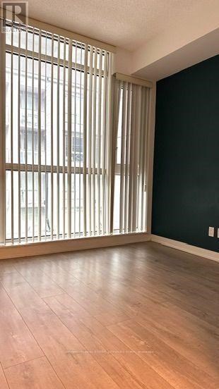 A room with a window covered by vertical blinds.