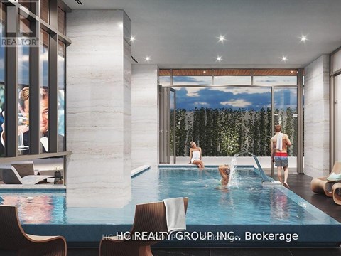 A modern indoor swimming pool with people enjoying the water.