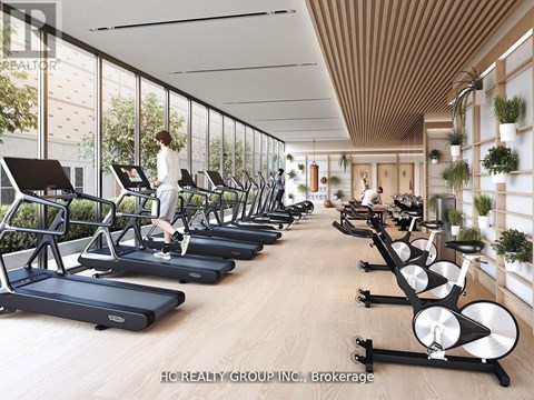 A gym with treadmills and a woman working out.