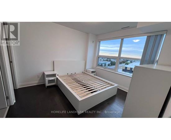 A bedroom with a large bed and a window overlooking a snowy landscape.