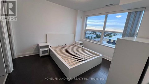 A bedroom with a large bed and a window overlooking a snowy landscape.