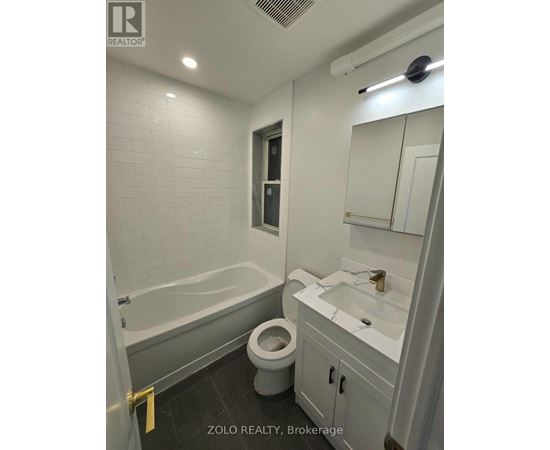 A bathroom with a toilet, sink, and bathtub.