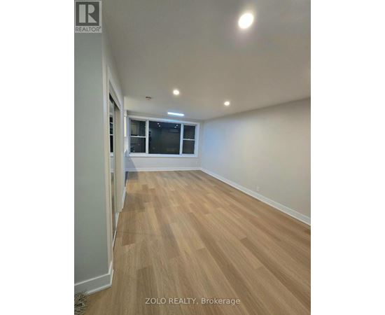 A room with wooden flooring and a window.
