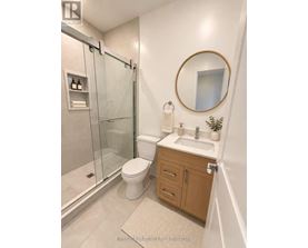A bathroom with a toilet, sink, and shower.