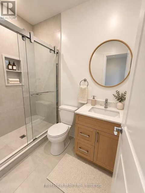 A bathroom with a toilet, sink, and shower.
