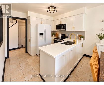 A kitchen with white cabinets and a white island.