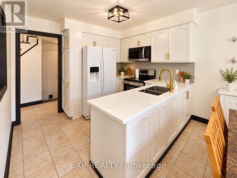 A kitchen with white cabinets and a white island.