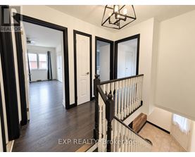 A hallway with a black railing and white walls.