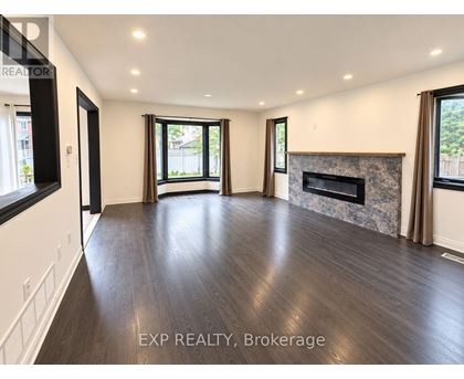 A spacious living room with wood flooring and a fireplace.