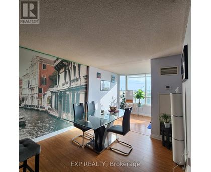 A living room with a glass table and chairs, a television, and a large picture of a canal on the wall.