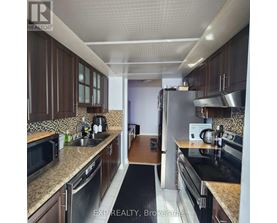 A kitchen with brown cabinets and stainless steel appliances.