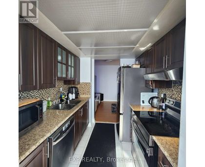 A kitchen with brown cabinets and stainless steel appliances.