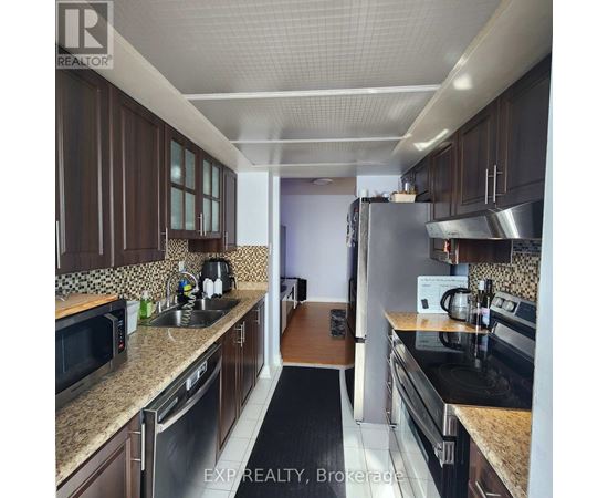 A kitchen with brown cabinets and stainless steel appliances.