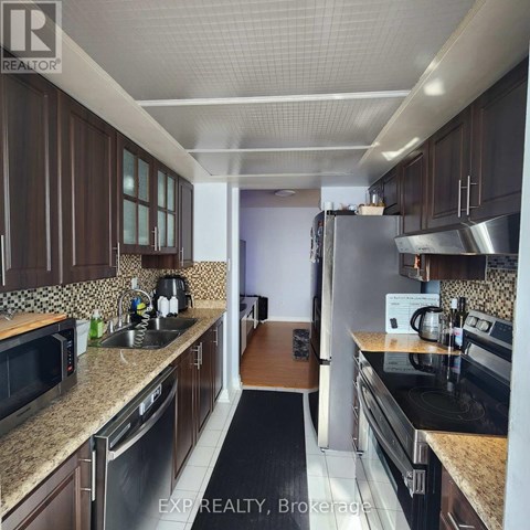 A kitchen with brown cabinets and stainless steel appliances.