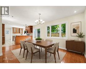 A dining room with a wooden table and chairs.