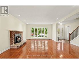 A spacious living room with a fireplace and hardwood floors.