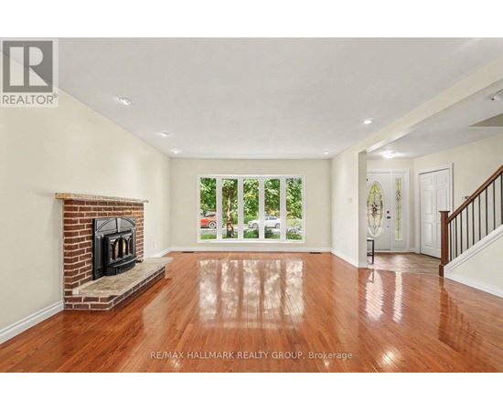 A spacious living room with a fireplace and hardwood floors.