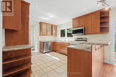 A kitchen with wooden cabinets and a stainless steel dishwasher.
