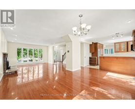 A spacious room with wooden floors and a chandelier.