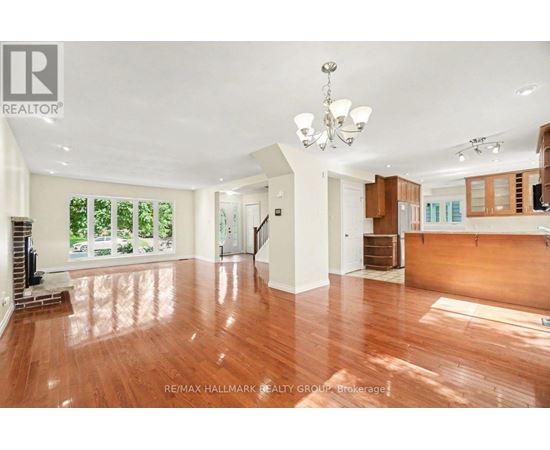 A spacious room with wooden floors and a chandelier.