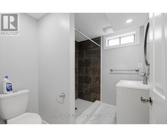 A white toilet sits next to a white sink in a bathroom.