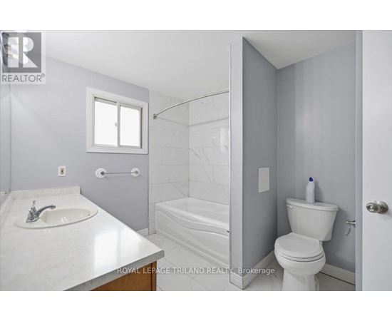 A white bathroom with a sink, toilet, and bathtub.