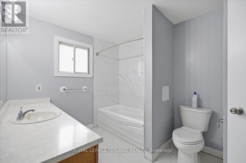 A white bathroom with a sink, toilet, and bathtub.