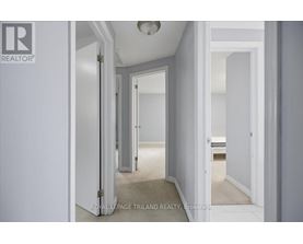 A hallway with white walls and a carpeted floor.