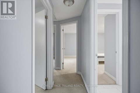 A hallway with white walls and a carpeted floor.