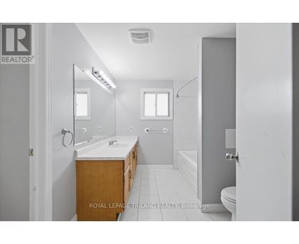 A bathroom with a sink, mirror, and bathtub.