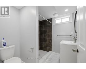 A white toilet sits next to a white sink in a bathroom.