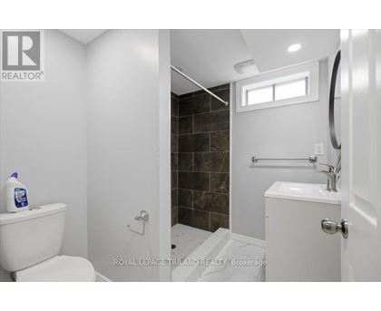 A white toilet sits next to a white sink in a bathroom.