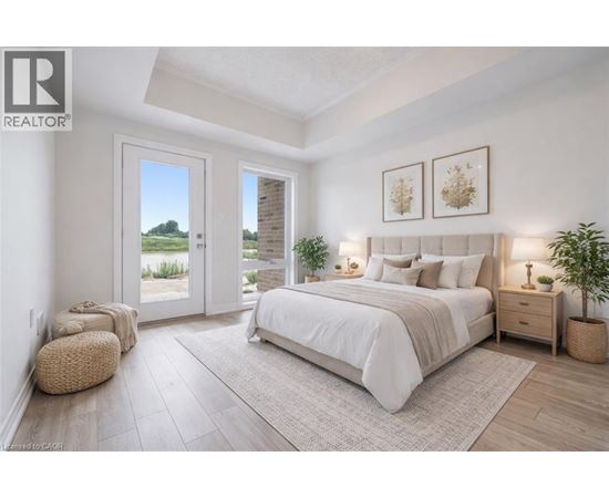 A bedroom with a large bed, a window with a view, and a plant on the side table.