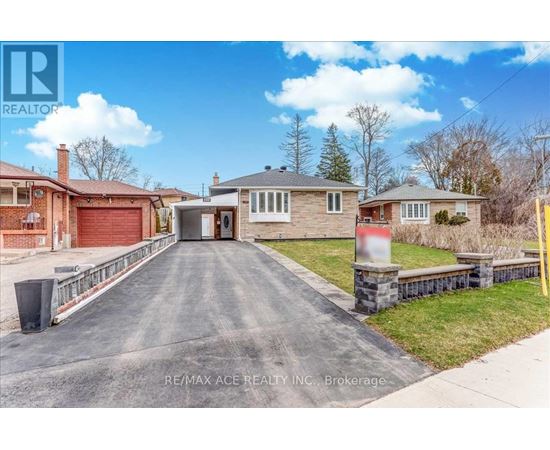 A real estate company's photo of a residential property with a driveway leading to a garage.